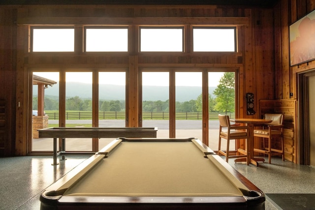 6971 W Cove Rd, Chickamauga, GA 30707 - recreation room featuring speckled floor, wood walls, pool table, plenty of natural light, and a towering ceiling