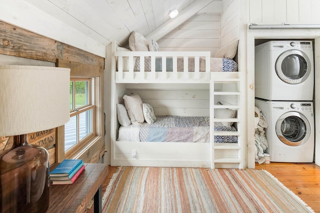 1170 Ascalon Rd, Rising Fawn, GA 30738 - bedroom featuring stacked washing machine and dryer, lofted ceiling, wood finished floors, and wood walls