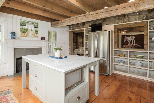 1170 Ascalon Rd, Rising Fawn, GA 30738 - kitchen with appliances with stainless steel finishes, a wooden ceiling with exposed beams, light wood-style floors, a fireplace with flush hearth, and a kitchen island
