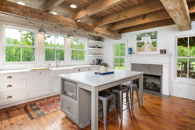 1170 Ascalon Rd, Rising Fawn, GA 30738 - kitchen featuring a kitchen bar, stainless steel microwave, a wooden ceiling with exposed beams, light wood-style flooring, and plenty of natural light