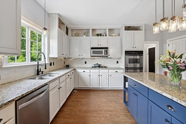 1209 Firth Ct, Franklin, TN 37067 - kitchen featuring appliances with stainless steel finishes, blue cabinetry, white cabinets, decorative backsplash, and wood finished floors