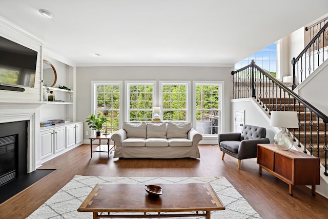 1209 Firth Ct, Franklin, TN 37067 - living area featuring crown molding, wood finished floors, stairs, a glass covered fireplace, and built in features