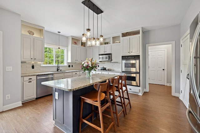 1209 Firth Ct, Franklin, TN 37067 - kitchen with stainless steel appliances, tasteful backsplash, a kitchen island, and light wood-type flooring