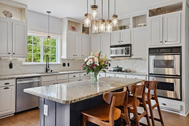 1209 Firth Ct, Franklin, TN 37067 - kitchen with appliances with stainless steel finishes, white cabinets, a center island, and wood finished floors