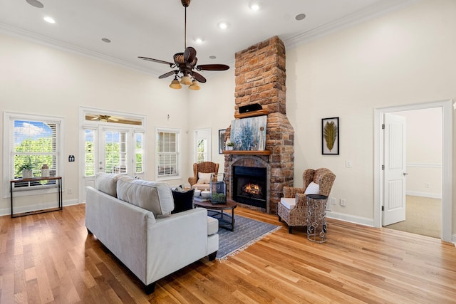 203 Tom Robinson Rd, Franklin, TN 37064 - living room with a towering ceiling, ceiling fan, a stone fireplace, ornamental molding, and wood finished floors