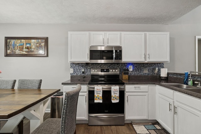 1804 Cason Trl, Murfreesboro, TN 37128 - kitchen featuring appliances with stainless steel finishes, backsplash, white cabinets, dark wood-style flooring, and a textured ceiling