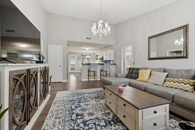 1804 Cason Trl, Murfreesboro, TN 37128 - living room featuring dark wood-type flooring, a chandelier, a textured ceiling, and a high ceiling