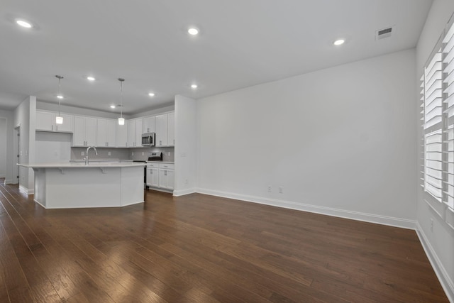1551 Cedarbrooke Ln, Lebanon, TN 37090 - kitchen featuring appliances with stainless steel finishes, light countertops, dark wood-style flooring, white cabinets, and a breakfast bar area