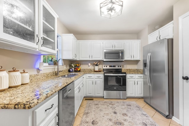 423 Adeline Dr, Smyrna, TN 37167 - kitchen with appliances with stainless steel finishes, light tile patterned floors, white cabinetry, and light stone counters