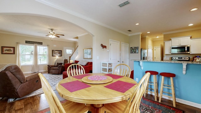 1095 Lady Nashville Dr, Hermitage, TN 37076 - dining area featuring dark wood finished floors, stairs, arched walkways, ceiling fan, and crown molding