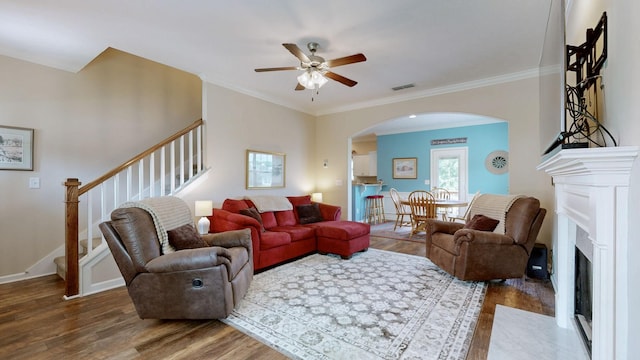 1095 Lady Nashville Dr, Hermitage, TN 37076 - living room featuring arched walkways, wood finished floors, stairs, a ceiling fan, and a fireplace with flush hearth