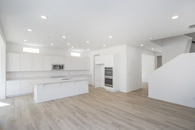 3044 Fernwood Ln, Columbia, TN 38401 - kitchen with stainless steel appliances, white cabinets, recessed lighting, a center island with sink, and light countertops