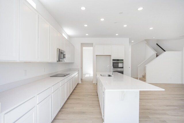 3044 Fernwood Ln, Columbia, TN 38401 - kitchen featuring appliances with stainless steel finishes, recessed lighting, light wood-style floors, a kitchen island with sink, and white cabinets