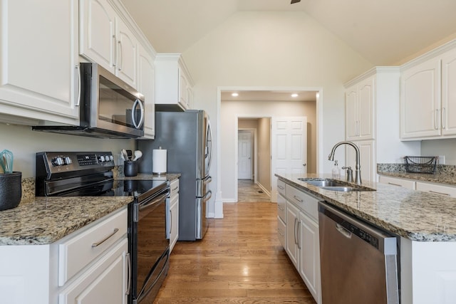 1057 The Long Run, Columbia, TN 38401 - kitchen featuring appliances with stainless steel finishes, white cabinetry, a center island with sink, light wood-style floors, and light stone countertops