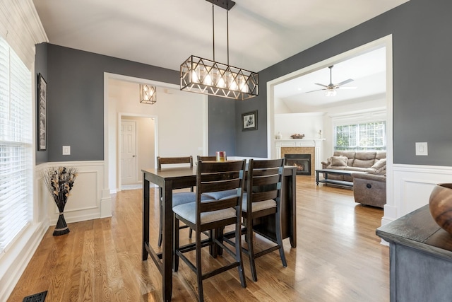 1057 The Long Run, Columbia, TN 38401 - dining space with wood finished floors, ceiling fan, wainscoting, a lit fireplace, and a decorative wall
