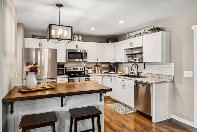 103 N Main St, Springfield, TN 37172 - kitchen featuring stainless steel appliances, butcher block countertops, dark wood-style floors, tasteful backsplash, and recessed lighting