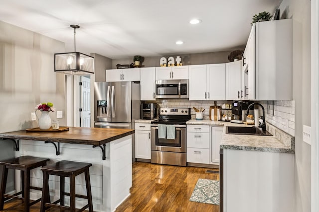 103 N Main St, Springfield, TN 37172 - kitchen with stainless steel appliances, a kitchen breakfast bar, tasteful backsplash, wooden counters, and dark wood-style flooring