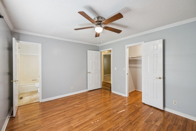 3171 Asbury Ln, Murfreesboro, TN 37129 - unfurnished bedroom with wood finished floors, crown molding, a walk in closet, a closet, and ensuite bathroom