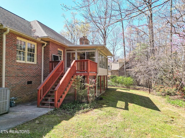 182 Whippoorwill Dr, Oak Ridge, TN 37830 - rear view of property featuring brick siding, a chimney, roof with shingles, a lawn, and a sunroom