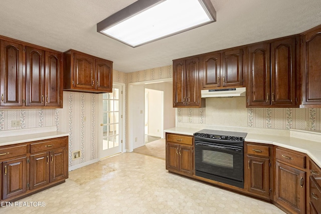 182 Whippoorwill Dr, Oak Ridge, TN 37830 - kitchen with under cabinet range hood, black range with electric stovetop, wallpapered walls, light floors, and light countertops