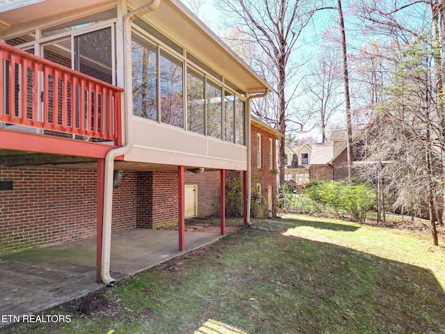 182 Whippoorwill Dr, Oak Ridge, TN 37830 - view of property exterior featuring a sunroom, a patio area, a yard, and brick siding