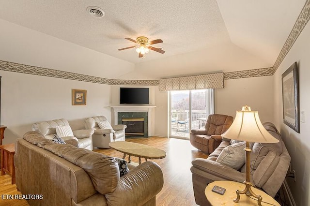 205 Ogle Dr Unit 554, Pigeon Forge, TN 37863 - living area with ceiling fan, light wood-type flooring, vaulted ceiling, a fireplace, and a textured ceiling