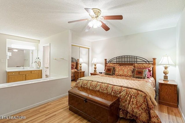 205 Ogle Dr Unit 554, Pigeon Forge, TN 37863 - bedroom with light wood-style floors, a closet, connected bathroom, a ceiling fan, and a textured ceiling