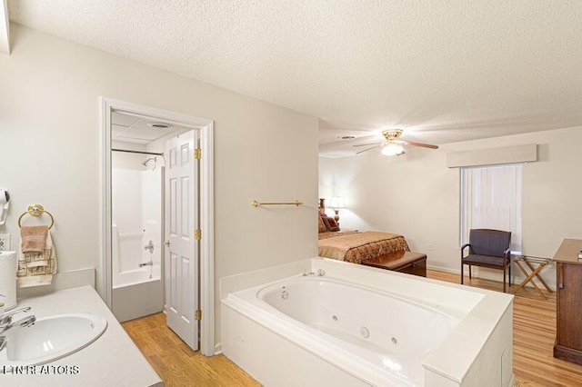 205 Ogle Dr Unit 554, Pigeon Forge, TN 37863 - full bathroom featuring a whirlpool tub, vanity, wood finished floors, a textured ceiling, and ceiling fan