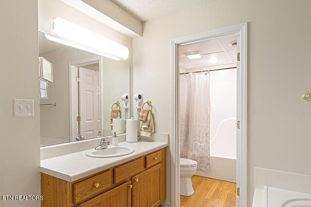 205 Ogle Dr Unit 554, Pigeon Forge, TN 37863 - full bathroom with vanity, wood finished floors, shower / tub combo with curtain, and a textured ceiling
