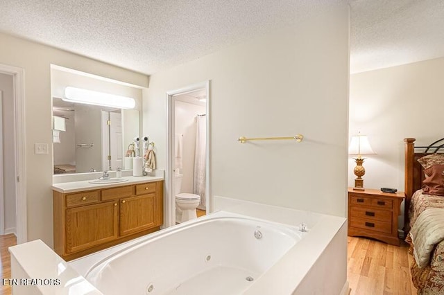 205 Ogle Dr Unit 554, Pigeon Forge, TN 37863 - full bath with a jetted tub, a textured ceiling, wood finished floors, vanity, and ensuite bath