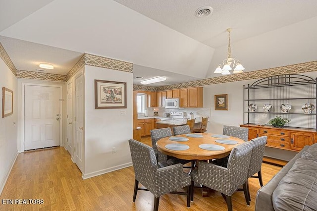 205 Ogle Dr Unit 554, Pigeon Forge, TN 37863 - dining room with a chandelier, light wood-style floors, and vaulted ceiling