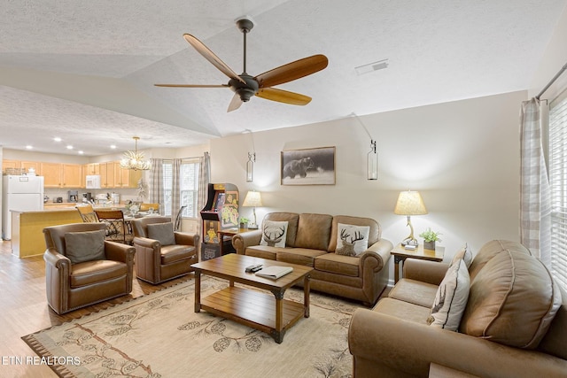 2032 Slippery Rock Cir, Sevierville, TN 37862 - living area featuring lofted ceiling, ceiling fan, light wood-type flooring, a textured ceiling, and a chandelier