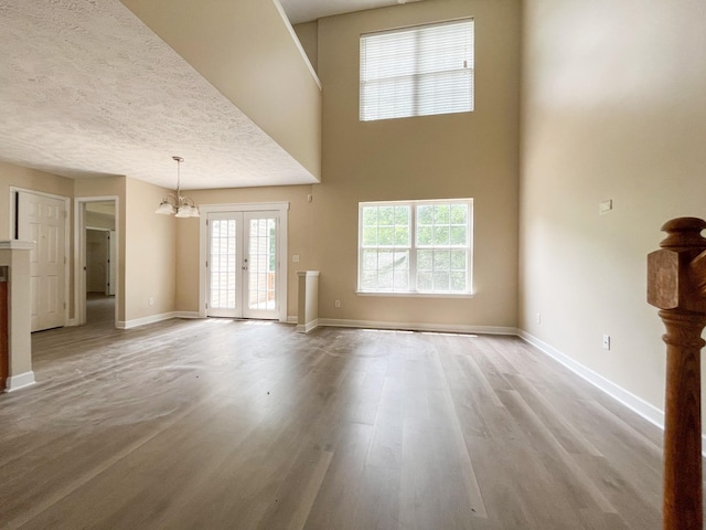 1564 Laurel Ledge Dr, La Vergne, TN 37086 - unfurnished living room with light wood-style floors, a chandelier, and french doors