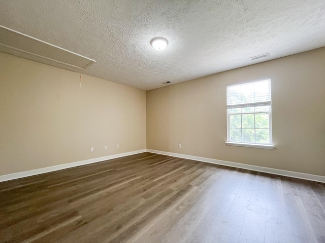1564 Laurel Ledge Dr, La Vergne, TN 37086 - spare room with dark wood-type flooring, attic access, and a textured ceiling