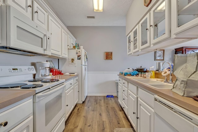 411 Churchill Xing, Madison, TN 37115 - kitchen featuring white appliances, light countertops, white cabinetry, light wood finished floors, and glass insert cabinets