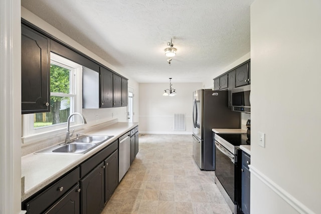 111 Platte Dr, Christiana, TN 37037 - kitchen with stainless steel appliances, a chandelier, light countertops, a textured ceiling, and hanging light fixtures