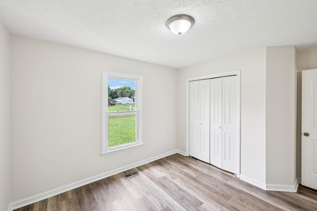 111 Platte Dr, Christiana, TN 37037 - unfurnished bedroom featuring light wood-type flooring, a closet, and a textured ceiling