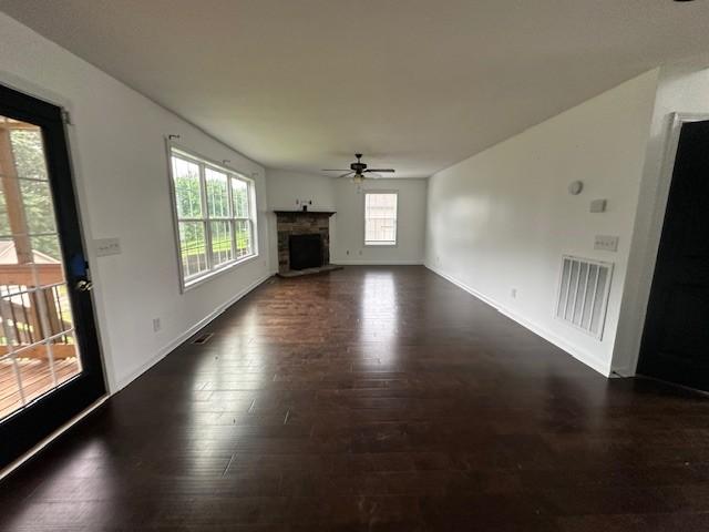 1248 Rich Ellen Dr, Palmyra, TN 37142 - unfurnished living room with ceiling fan, dark wood-type flooring, and a fireplace with raised hearth