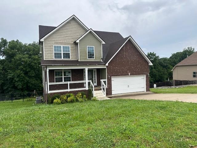 1248 Rich Ellen Dr, Palmyra, TN 37142 - traditional-style home featuring a porch, concrete driveway, an attached garage, and brick siding