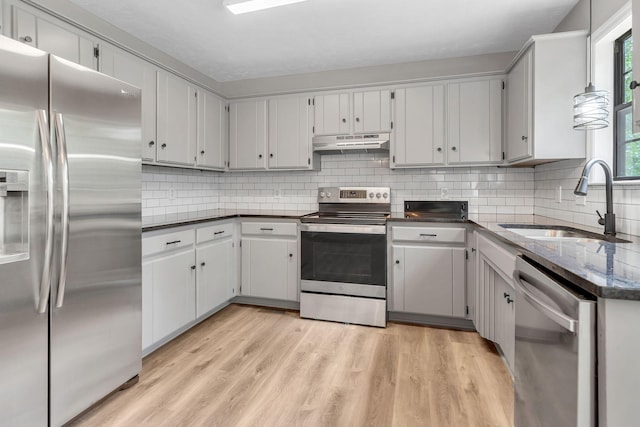 905 Septo Ct, Antioch, TN 37013 - kitchen featuring appliances with stainless steel finishes, under cabinet range hood, light wood-type flooring, and tasteful backsplash
