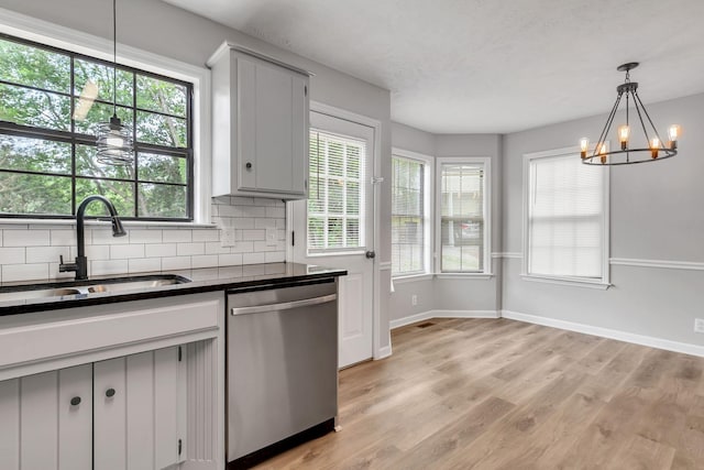 905 Septo Ct, Antioch, TN 37013 - kitchen with stainless steel dishwasher, dark countertops, tasteful backsplash, light wood-style floors, and gray cabinetry