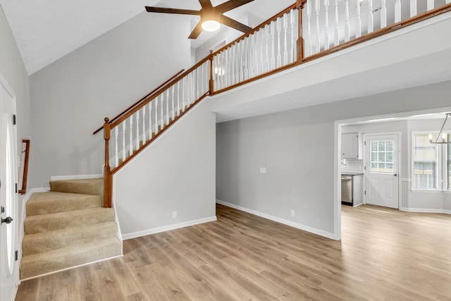 905 Septo Ct, Antioch, TN 37013 - unfurnished living room with high vaulted ceiling, stairs, a ceiling fan, wood finished floors, and a chandelier