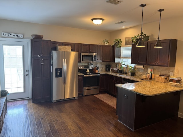 4803 Beryl Dr, Murfreesboro, TN 37128 - kitchen with stainless steel appliances, a peninsula, light stone counters, and dark wood finished floors