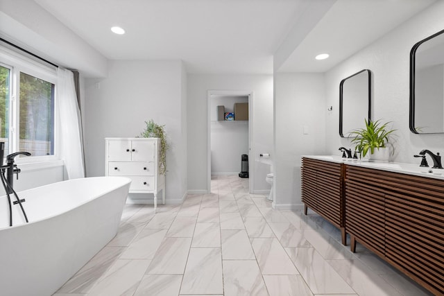 5920 Dogwood Dr, Harrison, TN 37341 - bathroom featuring double vanity, a freestanding tub, marble look tiles, and recessed lighting