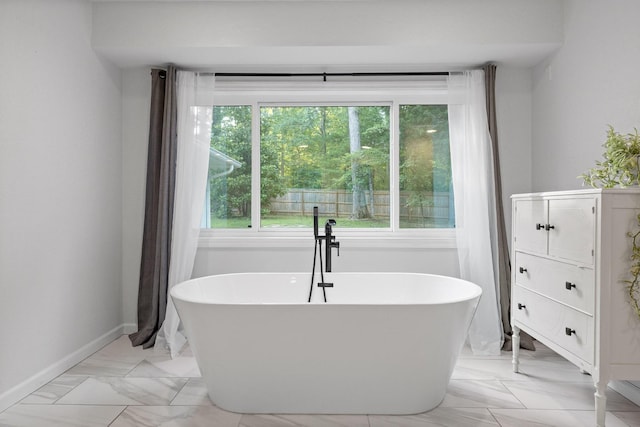 5920 Dogwood Dr, Harrison, TN 37341 - bathroom with plenty of natural light, a freestanding tub, and marble look tile flooring