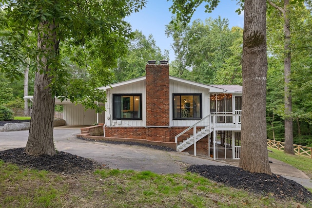 5920 Dogwood Dr, Harrison, TN 37341 - view of front of house featuring a sunroom, a chimney, brick siding, stairs, and driveway
