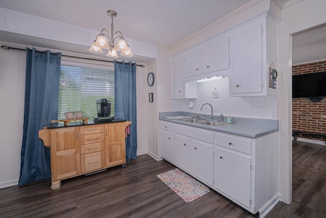 332 Old Dunbar Cave Rd, Clarksville, TN 37043 - kitchen featuring dark wood finished floors, a chandelier, white cabinetry, pendant lighting, and brick wall