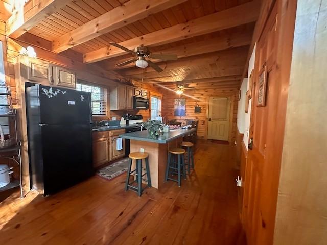 10 Meadow Brook Ln, Spencer, TN 38585 - kitchen with black appliances, wooden walls, dark wood-style floors, a kitchen breakfast bar, and ceiling fan