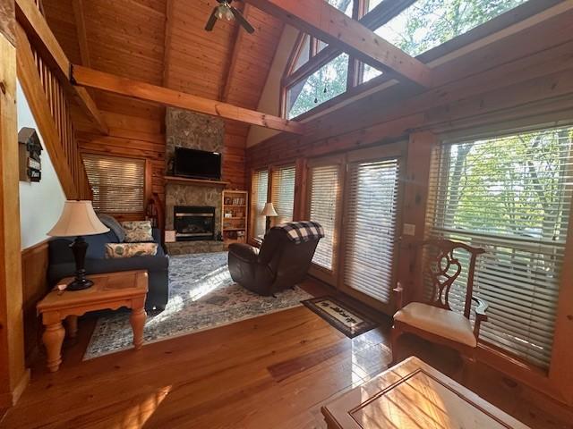 10 Meadow Brook Ln, Spencer, TN 38585 - living area featuring wood walls, high vaulted ceiling, wood finished floors, a ceiling fan, and a fireplace