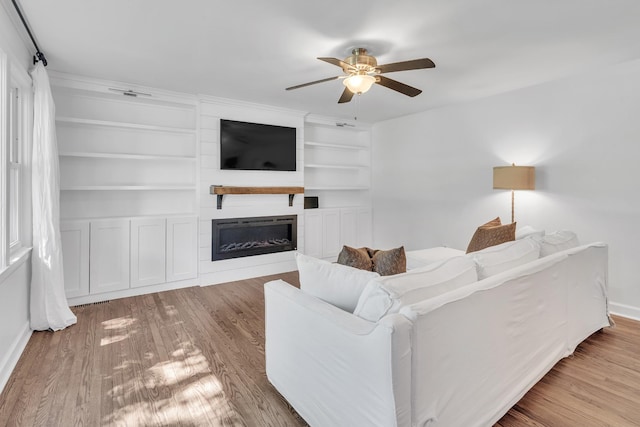 4200 Hunters Point Pike, Lebanon, TN 37087 - living room featuring a large fireplace, ceiling fan, wood finished floors, and built in shelves